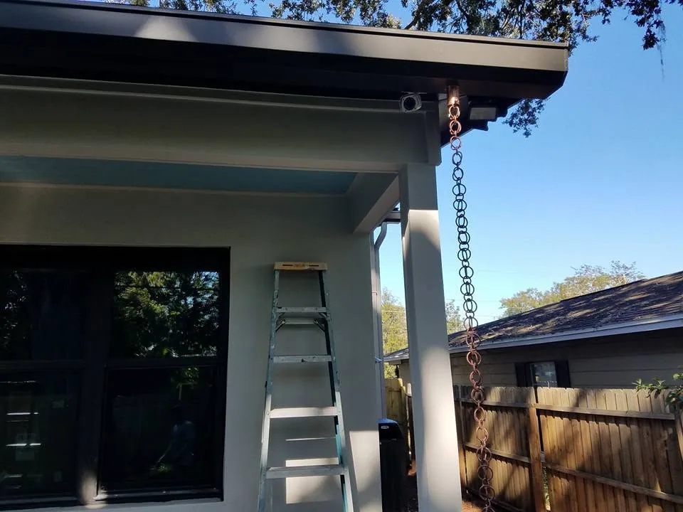 Copper rain chain flat roof corner gray stucco ladder, Sanford